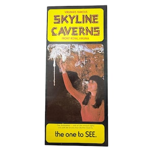 May include: A vintage Skyline Caverns brochure. The yellow and black brochure features the text "VIRGINIA'S FAMOUS SKYLINE CAVERNS" and a photo of a woman in an orange shirt. The text "the one to SEE" is also visible.