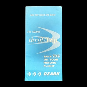 May include: A light blue vintage travel brochure for Fly Ozark, advertising "thrift-Trip" fares. The brochure features white text and graphics, including the phrase "Save 70% on your return flight."