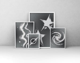 Könnte beinhalten: Eine Sammlung von fünf gerahmten Kunstdrucken mit einem Himmels-Thema. Die Drucke zeigen weiße Sternausbrüche, Galaxien und abstrakte Designs auf einem dunkelgrauen Hintergrund. Die Rahmen sind weiß, und die Kunstwerke werden vor einer neutralen Wand ausgestellt.