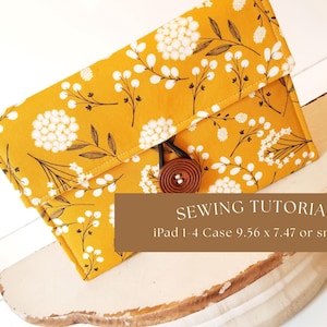 May include: A yellow fabric iPad case with a white floral pattern and a brown button closure. The case is on a white wooden surface. Sewing Tutorial iPad 1-4 Case 9.56 x 7.47 or smaller