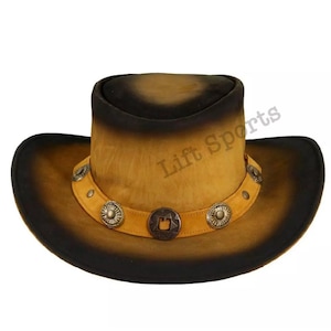 May include: A brown leather cowboy hat with a black brim and a band with silver accents. The hat has a distressed look and is decorated with a star-shaped design.