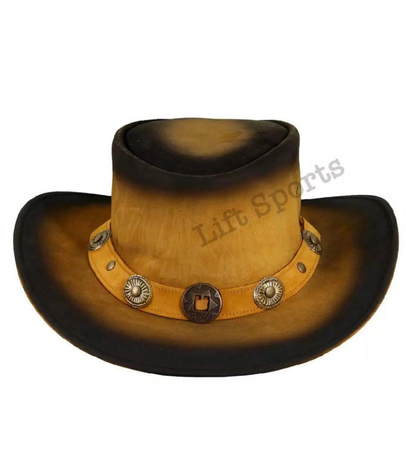 May include: A brown leather cowboy hat with a black brim and a band with silver accents. The hat has a distressed look and is decorated with a star-shaped design.