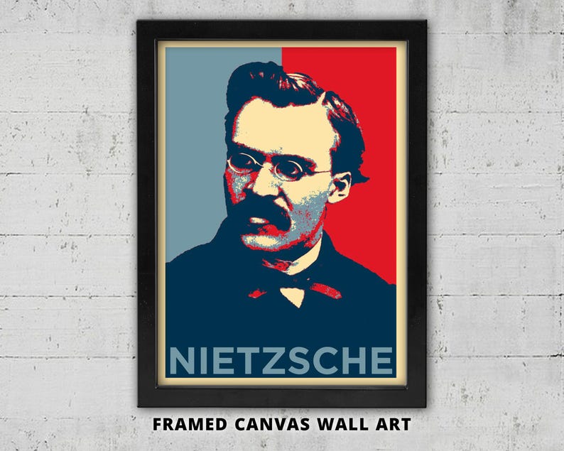 May include: Framed canvas wall art featuring a portrait of Friedrich Nietzsche in a pop art style. The image uses a color palette of red, blue, and beige. The name "NIETZSCHE" is displayed in white block letters at the bottom.