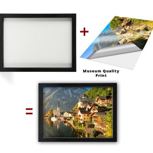 Puede incluir: Una impresi&oacute;n enmarcada en negro de un pueblo pintoresco junto a un lago y monta&ntilde;as. La imagen est&aacute; etiquetada como "Impresi&oacute;n de calidad de museo". El marco se muestra por separado, con la impresi&oacute;n y el marco combinados.