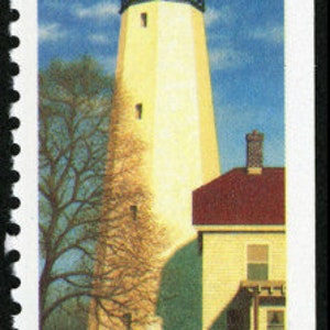 May include: A vintage 25 cent USA postage stamp featuring a white lighthouse with a red roof against a blue sky. The text "SANDY HOOK, NEW JERSEY" is printed below the lighthouse.