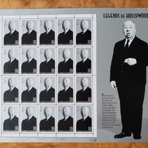 May include: A sheet of 20 silver stamps featuring a black and white portrait of Alfred Hitchcock. The stamps are arranged in four rows of five. The text "Legends of Hollywood" and a biography of Alfred Hitchcock are printed on the right side of the sheet.