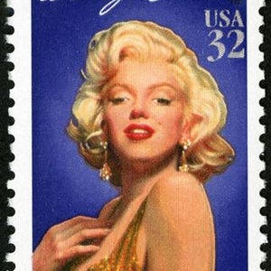 May include: A vintage-style US postage stamp featuring a portrait of Marilyn Monroe in a gold sequined dress. The stamp is blue and features the text "USA 32" and "Marilyn Monroe" in white.