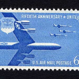 May include: A blue United States Air Force commemorative stamp with a B-52 bomber and the text "Fiftieth Anniversary * United States Air Force" and "U.S. Air Mail Postage 6¢".