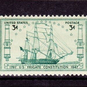 May include: A green 3-cent United States postage stamp featuring a depiction of the USS Constitution, a famous American frigate, with the text "1797 U.S. FRIGATE CONSTITUTION 1947".