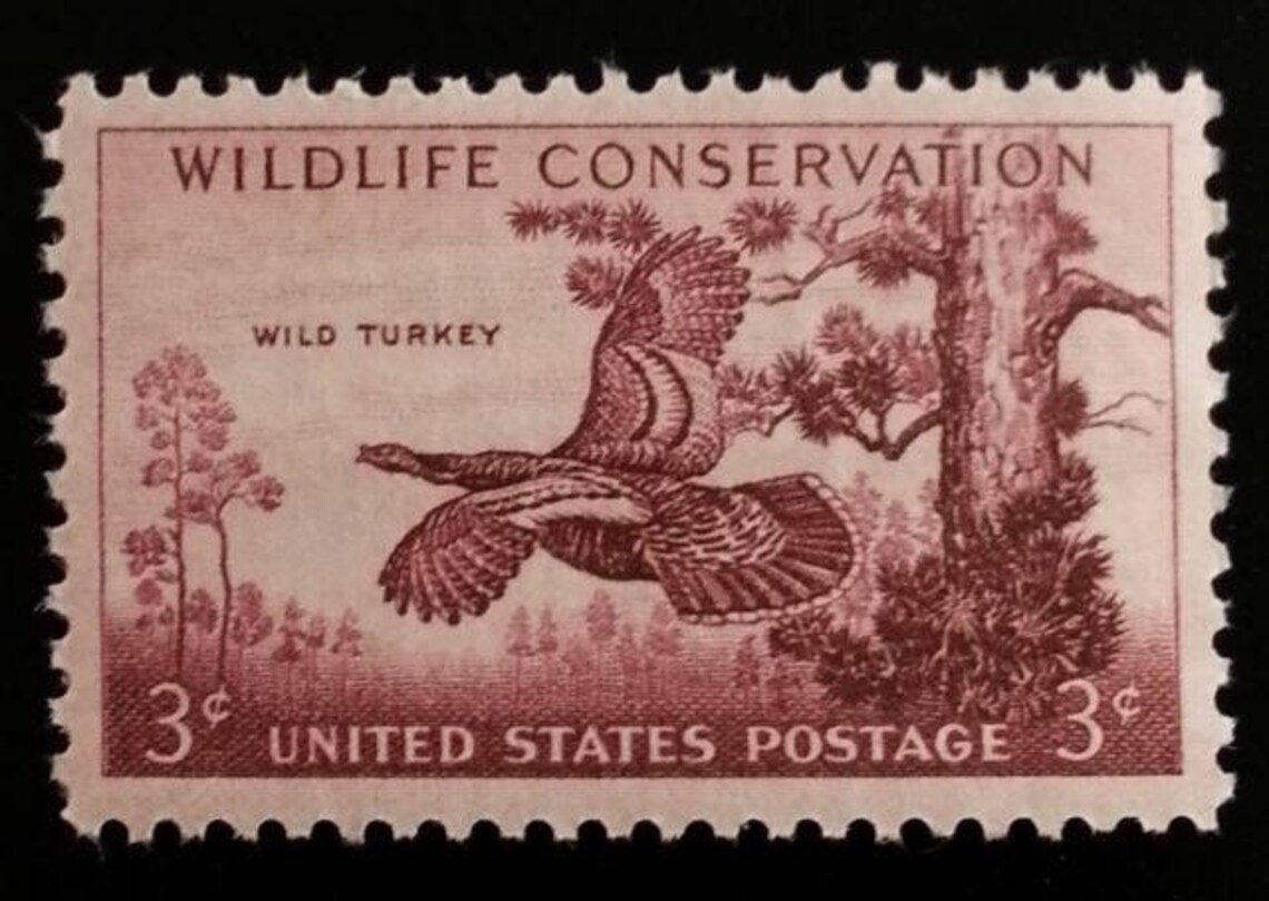 May include: A 3 cent United States postage stamp featuring a brown wild turkey in flight with the words 'WILDLIFE CONSERVATION' and 'WILD TURKEY' printed in brown. The stamp also features a brown tree and the words 'UNITED STATES POSTAGE' printed in brown.