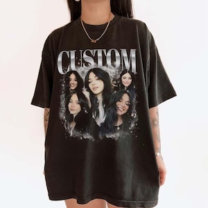 May include: Black oversized t-shirt with a graphic print of five women's faces and the word "CUSTOM" in silver lettering.