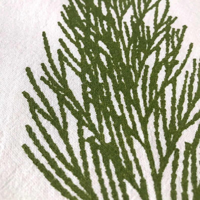 May include: Green leafy branch design printed on white fabric. The design is stylized and resembles a fern or other leafy plant.
