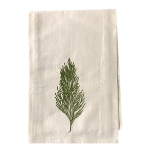 May include: A white cotton tea towel with a green embroidered pine tree design.