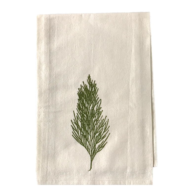 May include: A white cotton tea towel with a green embroidered pine tree design.