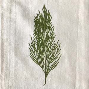 May include: A green leafy branch printed on a white fabric background.