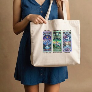 May include: A white canvas tote bag with three colorful stained glass-style images. The images are labeled "Velaris: City of Starlight", "Terrasen: To Whatever End", and "Lunathion: Light It Up".