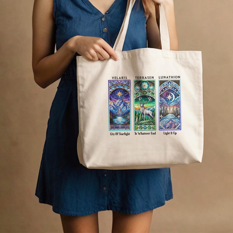 May include: A white canvas tote bag with three colorful stained glass-style images. The images are labeled "Velaris: City of Starlight", "Terrasen: To Whatever End", and "Lunathion: Light It Up".