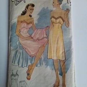 Puede incluir: Patrón de costura vintage para un vestido de deslizamiento, con dos mujeres que llevan la prenda. El patrón está etiquetado como "Economy Design" y "No. 17" con una talla de 36. El vestido de deslizamiento está disponible en dos colores, rosa y amarillo.