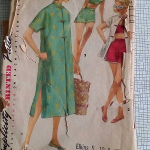 May include: Vintage Simplicity sewing pattern for a dress and two swimsuit styles. The pattern is for size 12, bust 30 inches. The dress is green with a floral print and has a mandarin collar and a side slit. The swimsuits are both two-piece and feature a red and white striped top and a solid red bottom. The pattern is printed on each pattern piece. The text "Elkins 5, 10 & 25c Store" is printed on the bottom of the pattern.