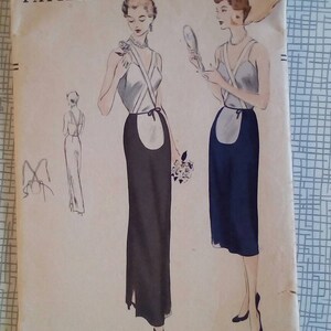 Può includere: Modello di cucito vintage Vogue per un abito con gonna e corpetto. Il modello è per un'anca di 37 e risale al 1984. Il modello mostra due donne che indossano l'abito, una con una gonna nera e l'altra con una gonna blu.