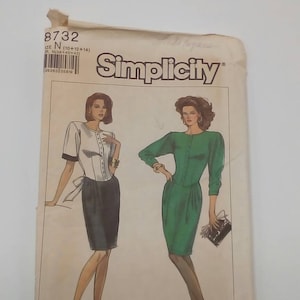 May include: Simplicity sewing pattern number 8732 for sizes 10, 12, and 14. The pattern features two women's dresses, one in white and black and the other in green. The pattern is labeled "Easy to Sew" and "Facile a Coudre".