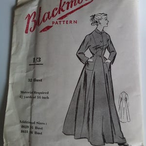 Op de afbeelding: Blackmore naaipatroon envelop voor een jurk. De envelop toont een lijntekening van een vrouw die een lange jurk draagt met een kraag en zakken. Het patroonnummer is 8627 en de maat is 32 bust. De envelop vermeldt ook extra maten 34 en 36 bust. Het patroon vereist 4 1/8 yards stof van 54 inch breed.