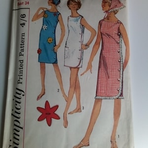 May include: Simplicity sewing pattern number 2483 for a sleeveless dress with a side button closure. The pattern is for a size 14 with a bust measurement of 34 inches. The pattern includes three different dress styles with floral, white, and red gingham fabric.