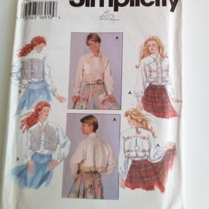 May include: Simplicity sewing pattern number 9653 for a blouse with a lace trim. The pattern includes four different views of the blouse, with different sleeve lengths and necklines. The pattern is printed on white paper with black text.
