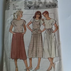 May include: A vintage sewing pattern for a dress with a striped top and a skirt. The pattern is for sizes 10, 12, and 14. The pattern is called "Style" and the number is 4043.