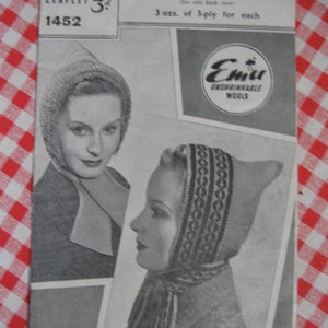 Könnte beinhalten: Ein Vintage-Strickmusterheft für vier Kapuzenmützen. Der Umschlag des Heftes zeigt ein Schwarzweißfoto einer Frau, die eine gestrickte Mütze und einen Schal trägt. Das Heft trägt den Titel "Four Hoods" und enthält den Text "3 ozs. of 3-ply for each" und "Emu Unshrinkable Wools".