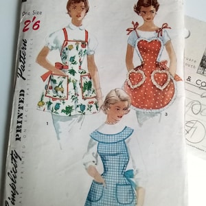 May include: Vintage sewing pattern for one-yard aprons. The pattern shows three different styles of aprons: a floral print apron with a pocket, a red polka dot apron with heart-shaped details, and a blue and white gingham apron with a bow. The pattern is labelled "Simplicity Printed Pattern" and "1359 One-Yard Aprons".
