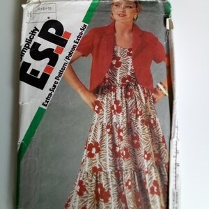 May include: A vintage sewing pattern envelope for a dress and jacket. The pattern number is 6833 and the brand is Simplicity ESP. The model is wearing a red jacket and a brown and white floral dress.