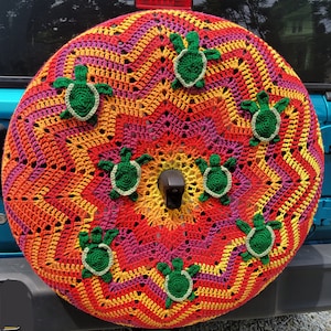Funda de rueda de repuesto tejida a crochet con forma de tortuga marina al atardecer