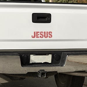 May include: A white pickup truck with a red word art decal on the tailgate. The decal is a circle of words including "love", "life", "joy", "peace", "hope", "faith", "mercy", "truth", "strength", "freedom", "redemption", "salvation", "purpose", and "power".