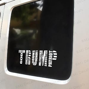 May include: A black and white decal sticker with the words "God, Freedom, Constitution, Rights, Guns, Pride, Honor, Hope, Bible, Military, Veterans, Ammo, Patriot, Unity" arranged vertically in a diagonal line.