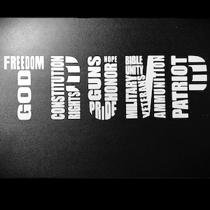 May include: Black and white image with the word "TRUMP" spelled out vertically using words like "God", "Freedom", "Constitution", "Rights", "Guns", "Pride", "Hope", "Honor", "Bible", "Unity", "Military", "Veterans", "Ammunition", and "Patriot".