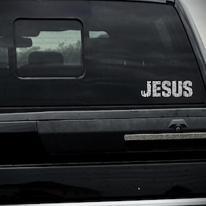 May include: A black truck with a white vinyl decal on the rear window. The decal is a word cloud of positive words, including "love", "hope", "peace", "faith", "joy", "strength", "mercy", "truth", "freedom", "purpose", and "salvation".