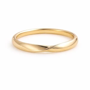 May include: A gold-colored ring with a twisted design. The ring has a smooth, polished surface and a simple, elegant style. The ring is a size 7.
