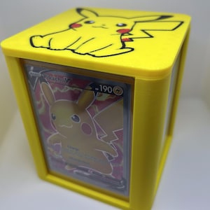 May include: Yellow card holder with a Pikachu illustration on the top and a Pokemon card featuring Pikachu inside. The card is a holographic card with the number 190.