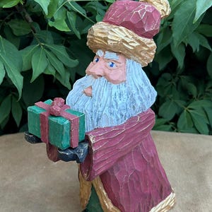 Santa holding wrapped present