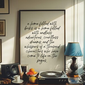 May include: A black and white framed print with a quote about books and adventures. The quote reads: "a home filled with books is a home filled with endless adventures, countless dreams, and the whispers of a thousand characters who have come to life on the pages."