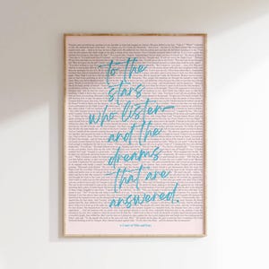 May include: A framed art print with a pink background and a book excerpt. The text "To the stars who listen and the dreams that are answered" is in turquoise script. The title "A Court of Mist and Fury" is at the bottom.