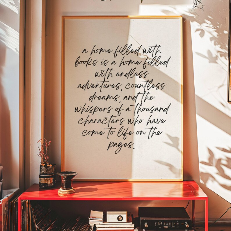 May include: A white framed print with a black handwritten quote about books and home. The quote reads: "A home filled with books is a home filled with endless adventures, countless dreams, and the whispers of a thousand characters who have come to life on the pages."