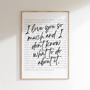 May include: A framed art print with a white background and black text. The text reads "I love you so much and I don't know what to do about it." The print has a wooden frame and includes additional text in a foreign language.