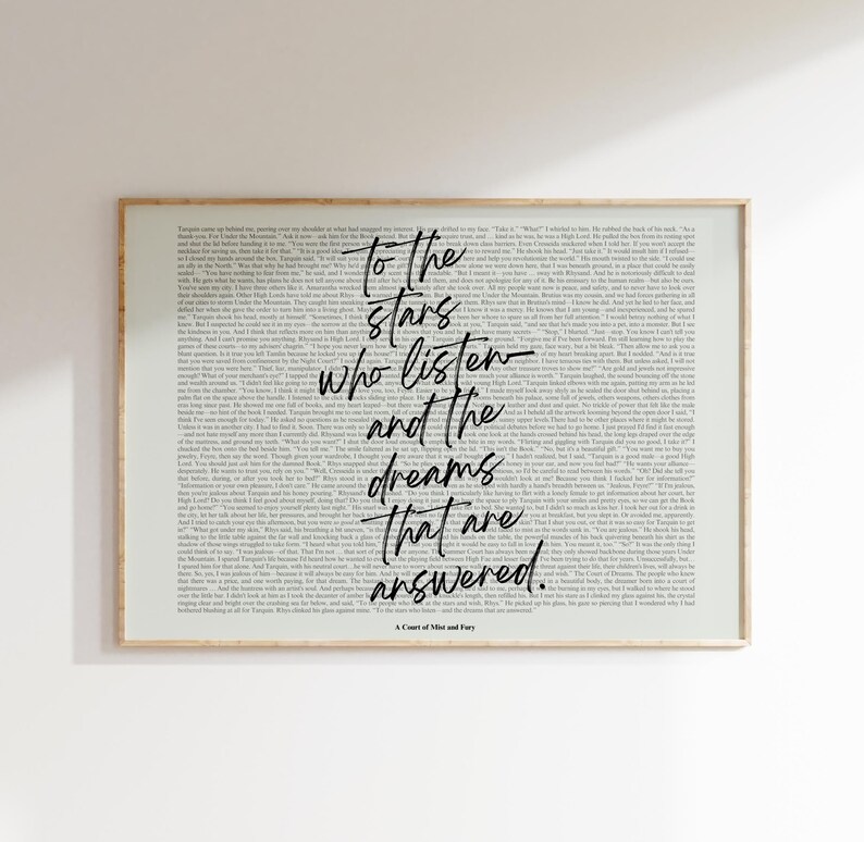 May include: A framed print with a light background filled with small text. The center features the quote "To the stars who listen and the dreams that are answered" in black script. The frame is a light brown color.