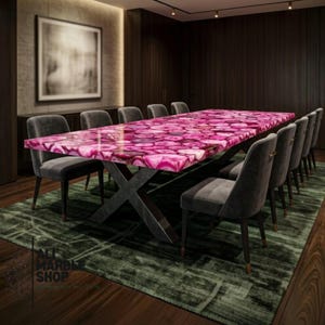 May include: A rectangular dining table featuring a polished surface made of vibrant pink agate slices with natural white banding. The tabletop is supported by a dark gray metal base with an X-shaped design, surrounded by several gray upholstered chairs.