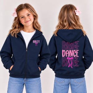 May include: A navy blue zip-up hoodie featuring a white undershirt. The front displays the name HALEY in pink above a pink bow icon. The back features the word DANCE repeated in pink text with a central pink bow graphic.