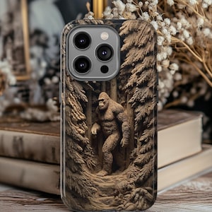 May include: A phone case featuring a detailed relief of a Bigfoot figure in a forest setting. The case is brown with a textured appearance, and the Bigfoot is depicted walking through a wooded area. The case has a camera cutout.