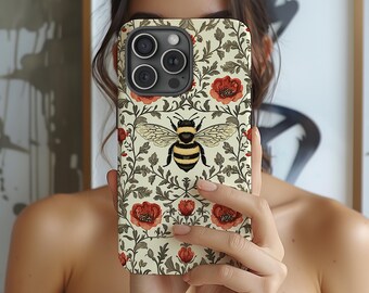 May include: A phone case featuring a bee design. The case has a cream background with red flowers and green leaves. The bee is centered with black and yellow stripes and detailed wings. The case is designed for a smartphone.