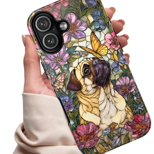 May include: A phone case featuring a pug dog design with a butterfly and floral elements. The case has a colorful stained-glass style with pink, purple, and blue flowers. The pug is light brown with a dark brown face.